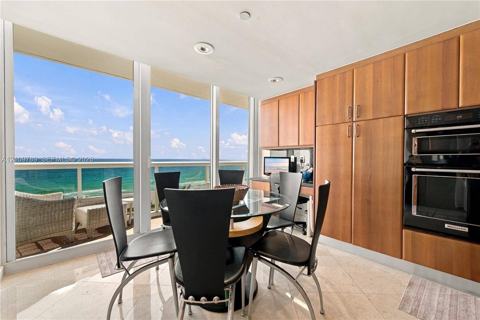 9595 Collins Avenue, #N6-B, Surfside, Surfside, FL 33154 Floor-to-ceiling windows, natural stone flooring, custom wood-finish cabinetry, built-in double wall oven, and balcony access