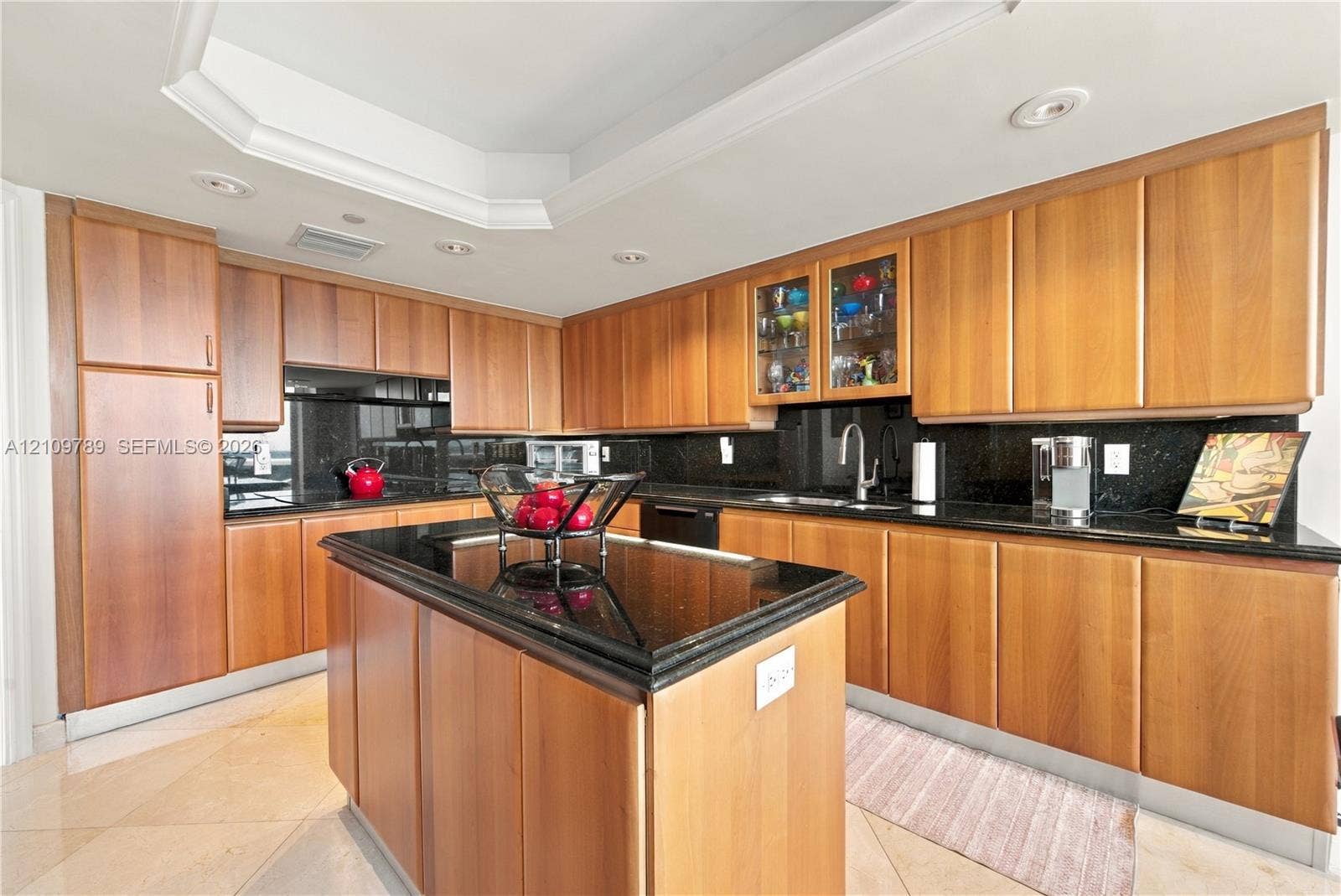 9595 Collins Avenue, #N6-B, Surfside, Surfside, FL 33154 Kitchen featuring wood cabinetry, black countertops, central island, tray ceiling, and recessed lighting