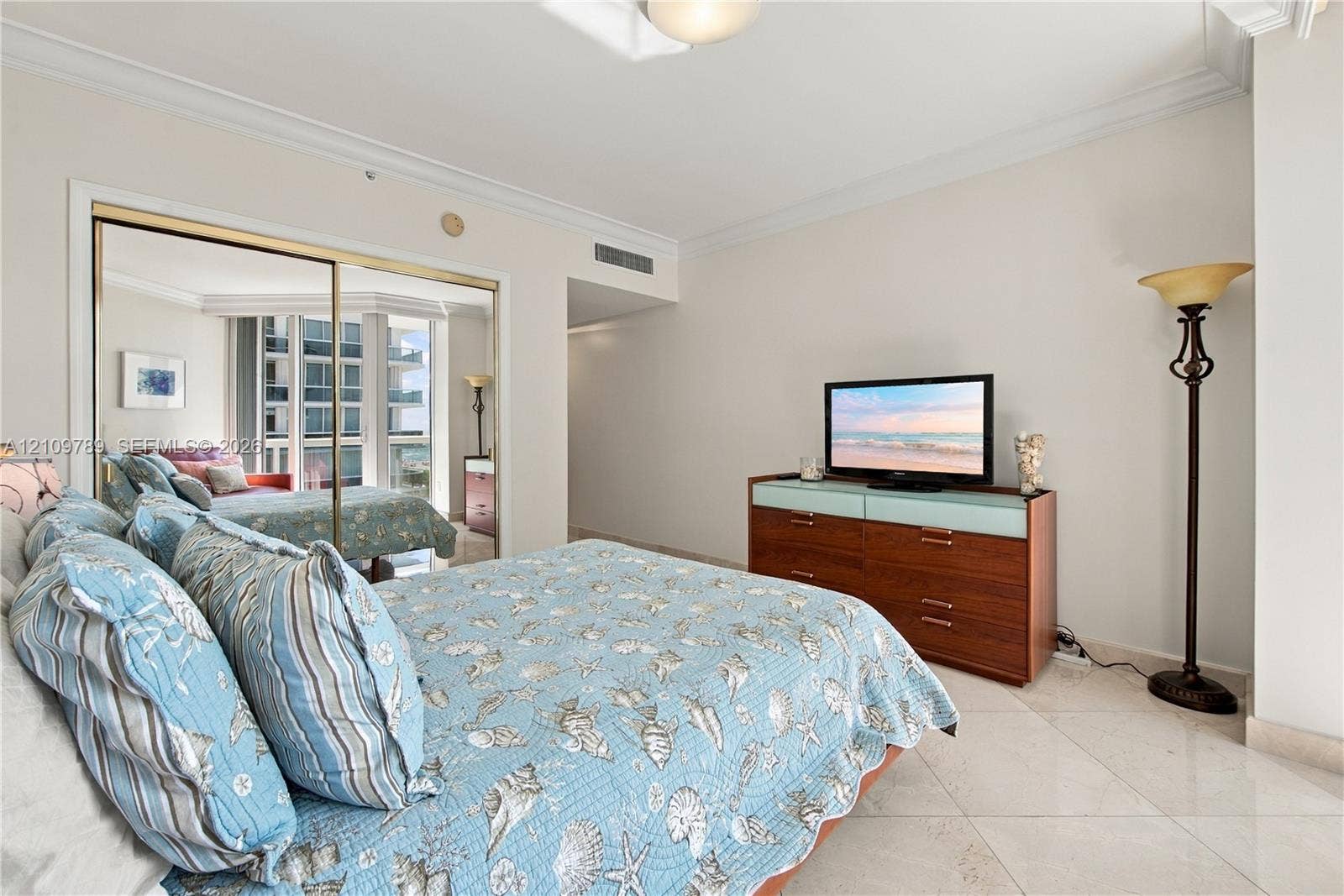 9595 Collins Avenue, #N6-B, Surfside, Surfside, FL 33154 Bedroom featuring neutral walls, crown molding, polished tile flooring, and a mirrored sliding-door closet