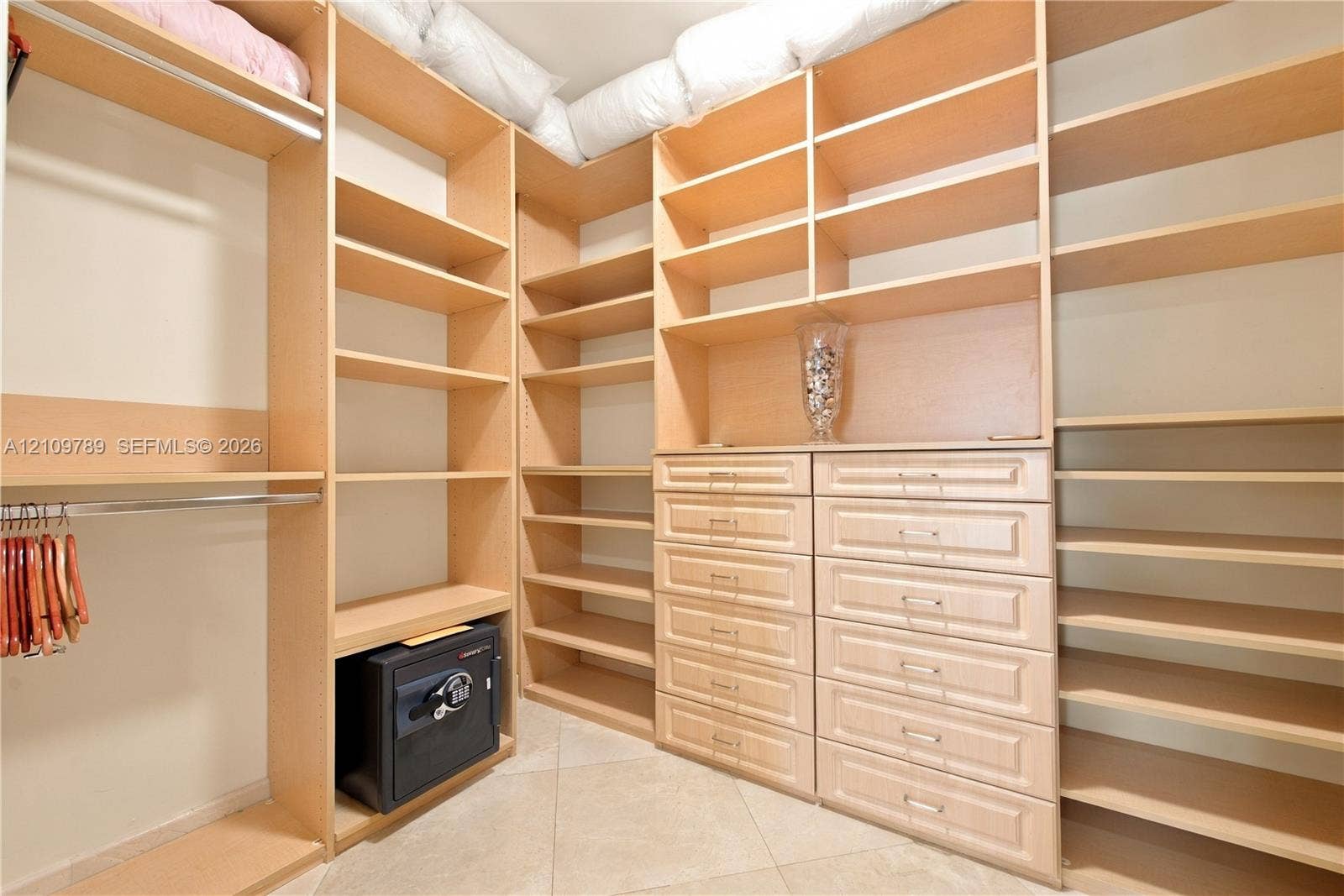 9595 Collins Avenue, #N6-B, Surfside, Surfside, FL 33154 Walk-in closet featuring light wood-finish built-in shelving, integrated dresser drawers with metal hardware, and dual clothing rods