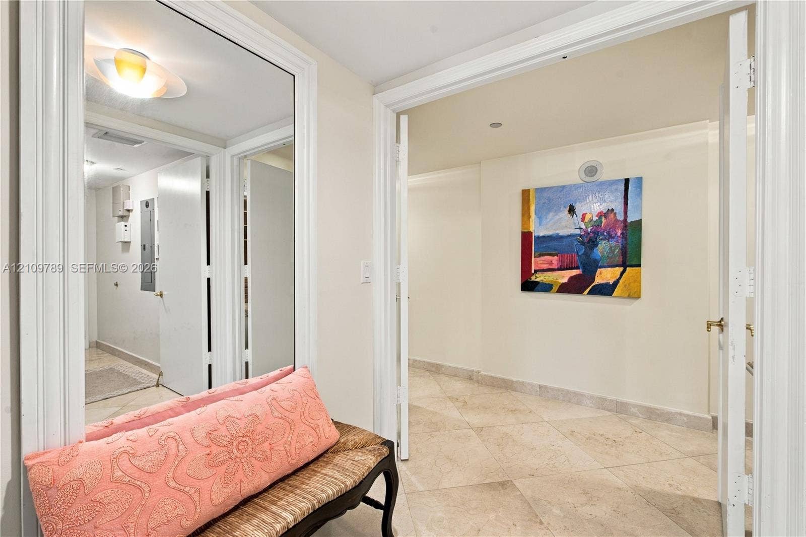 9595 Collins Avenue, #N6-B, Surfside, Surfside, FL 33154 Neutral stone flooring, large wall-mounted mirror, and detailed door casing