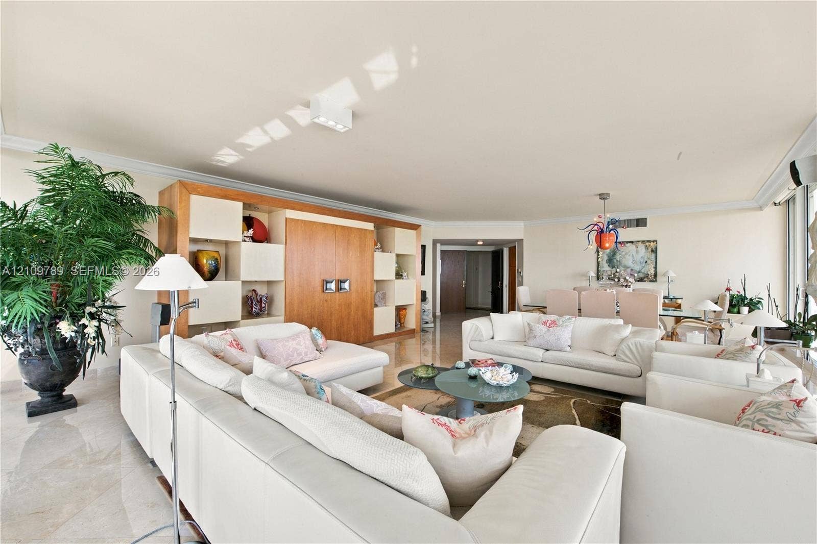 9595 Collins Avenue, #N6-B, Surfside, Surfside, FL 33154 Open-concept interior featuring large-format stone flooring, crown molding, and extensive built-in cabinetry with integrated shelving