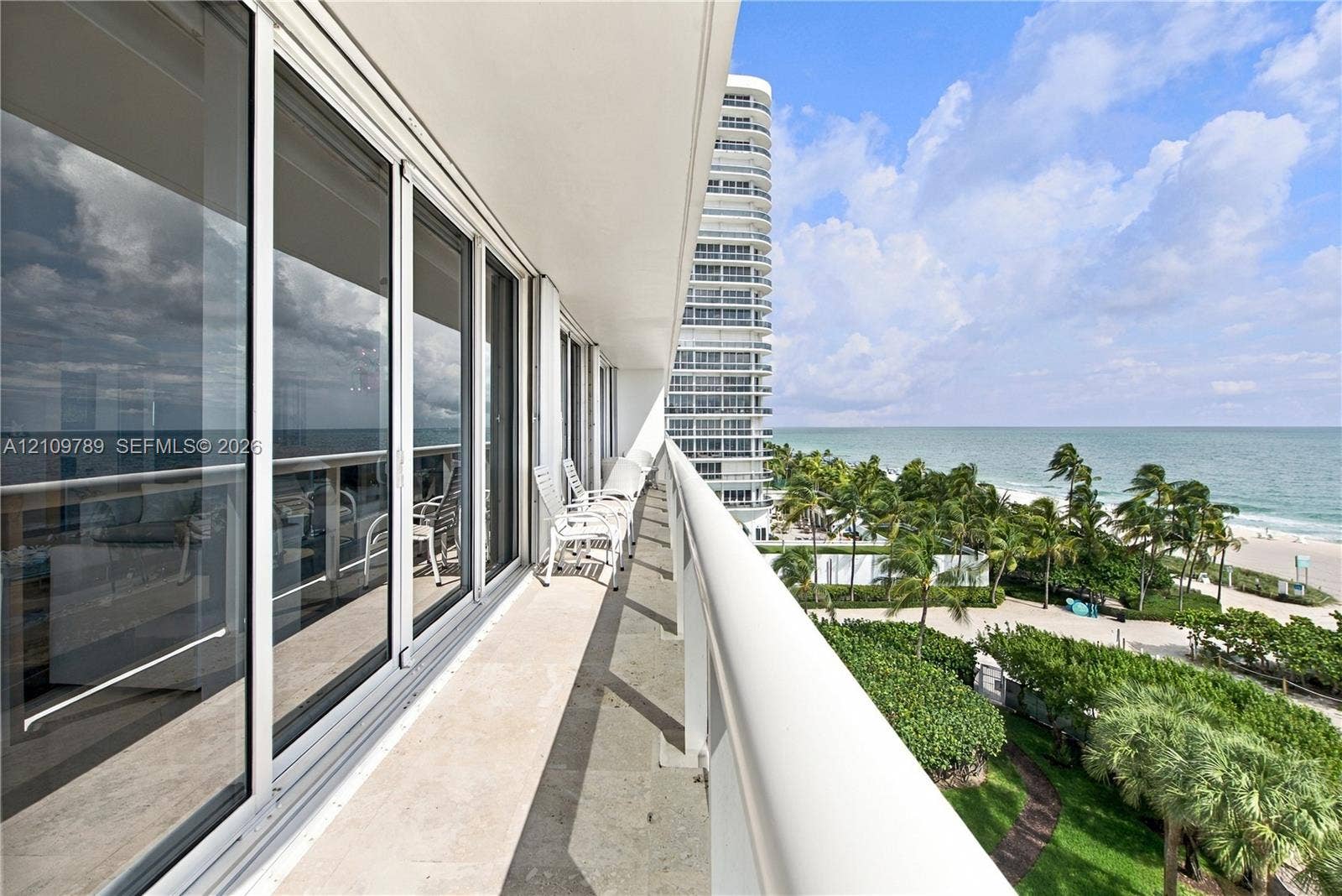 9595 Collins Avenue, #N6-B, Surfside, Surfside, FL 33154 Covered balcony featuring stone flooring, a white metal railing, and floor-to-ceiling sliding glass doors