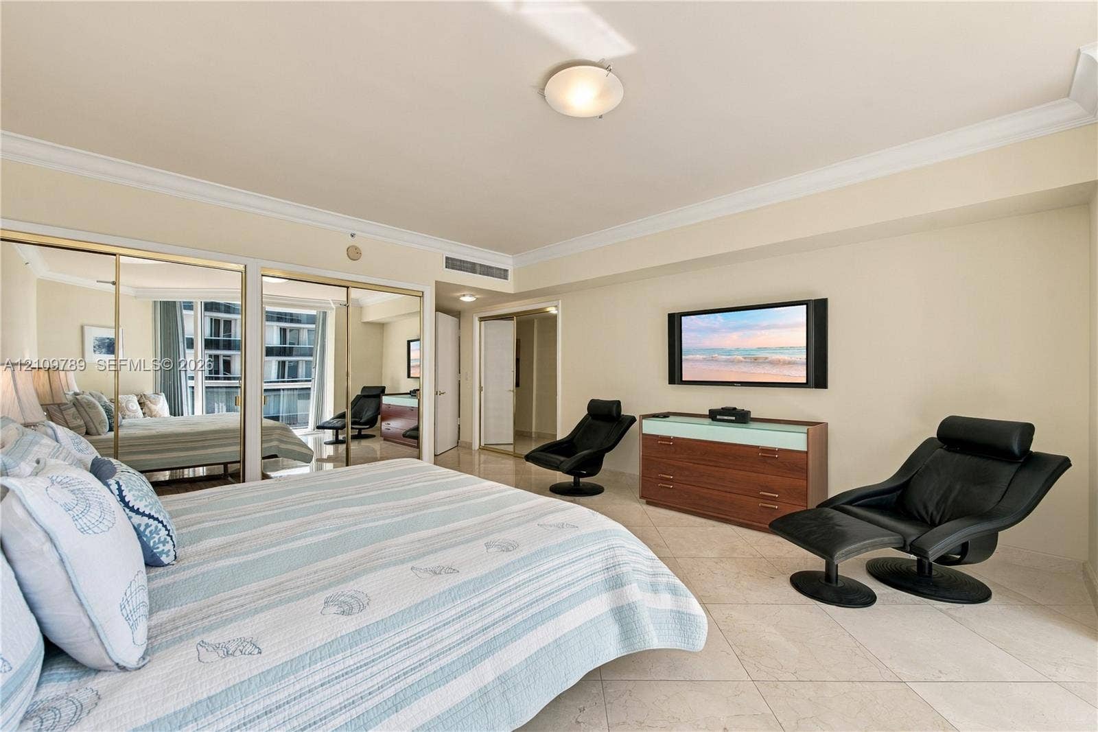 9595 Collins Avenue, #N6-B, Surfside, Surfside, FL 33154 Neutral-toned interior featuring large-format tile flooring, crown molding, and floor-to-ceiling mirrored closet doors