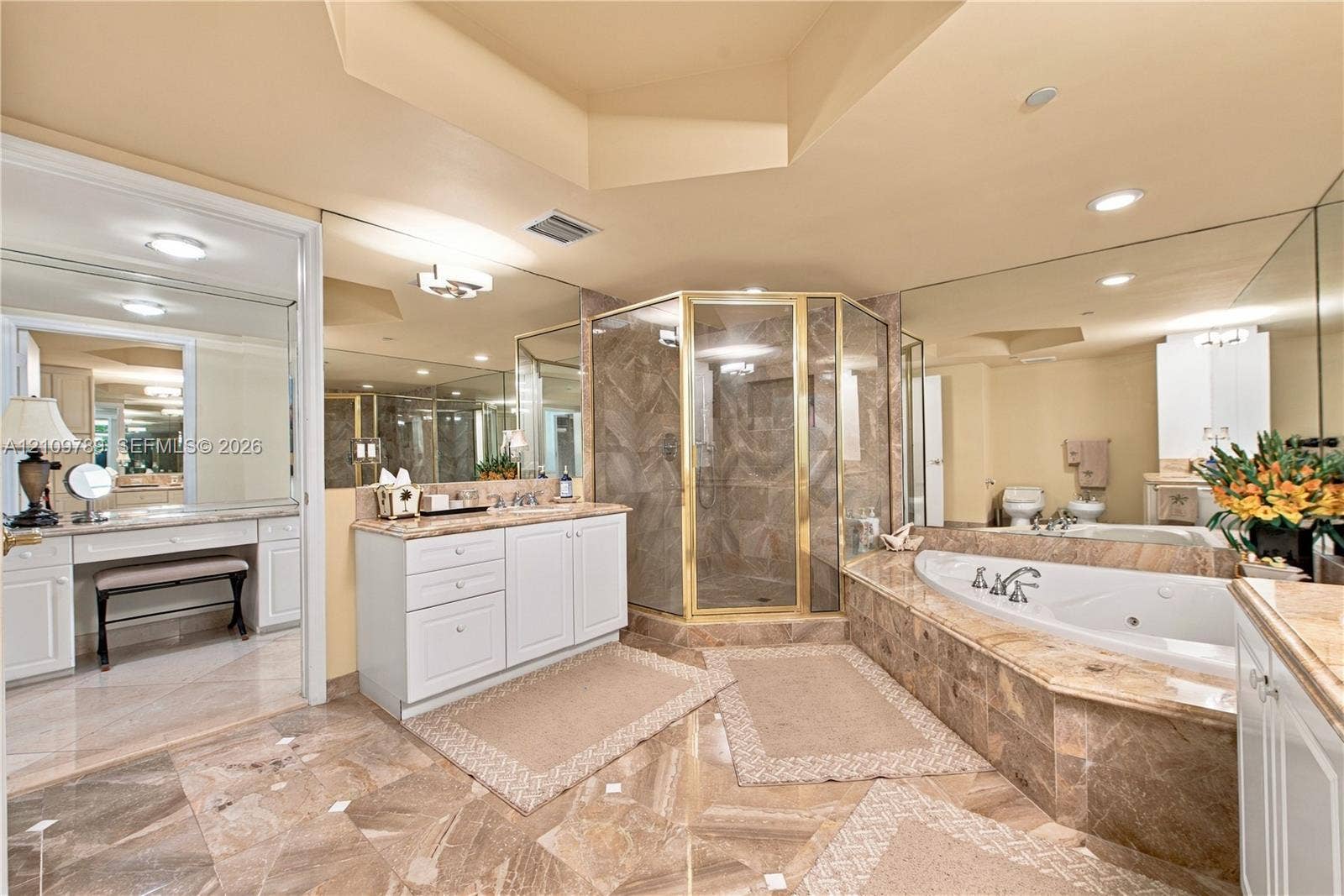 9595 Collins Avenue, #N6-B, Surfside, Surfside, FL 33154 Bathroom featuring stone tile flooring, a built-in vanity with cabinetry, a jetted soaking tub with a stone surround, and a walk-in shower with metal framing