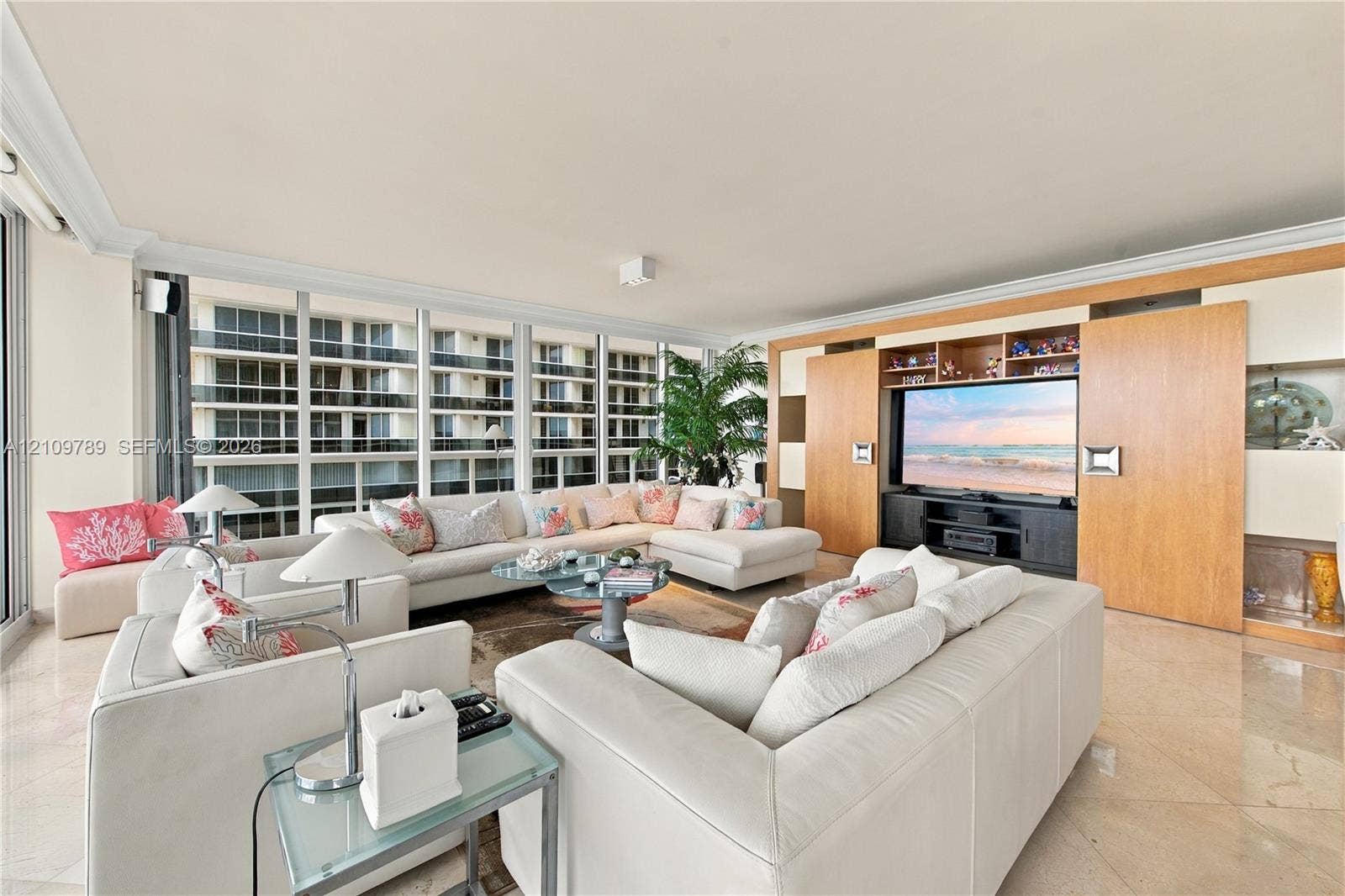 9595 Collins Avenue, #N6-B, Surfside, Surfside, FL 33154 Living area featuring floor-to-ceiling windows, polished stone flooring, and custom wood-finish built-in cabinetry with integrated shelving
