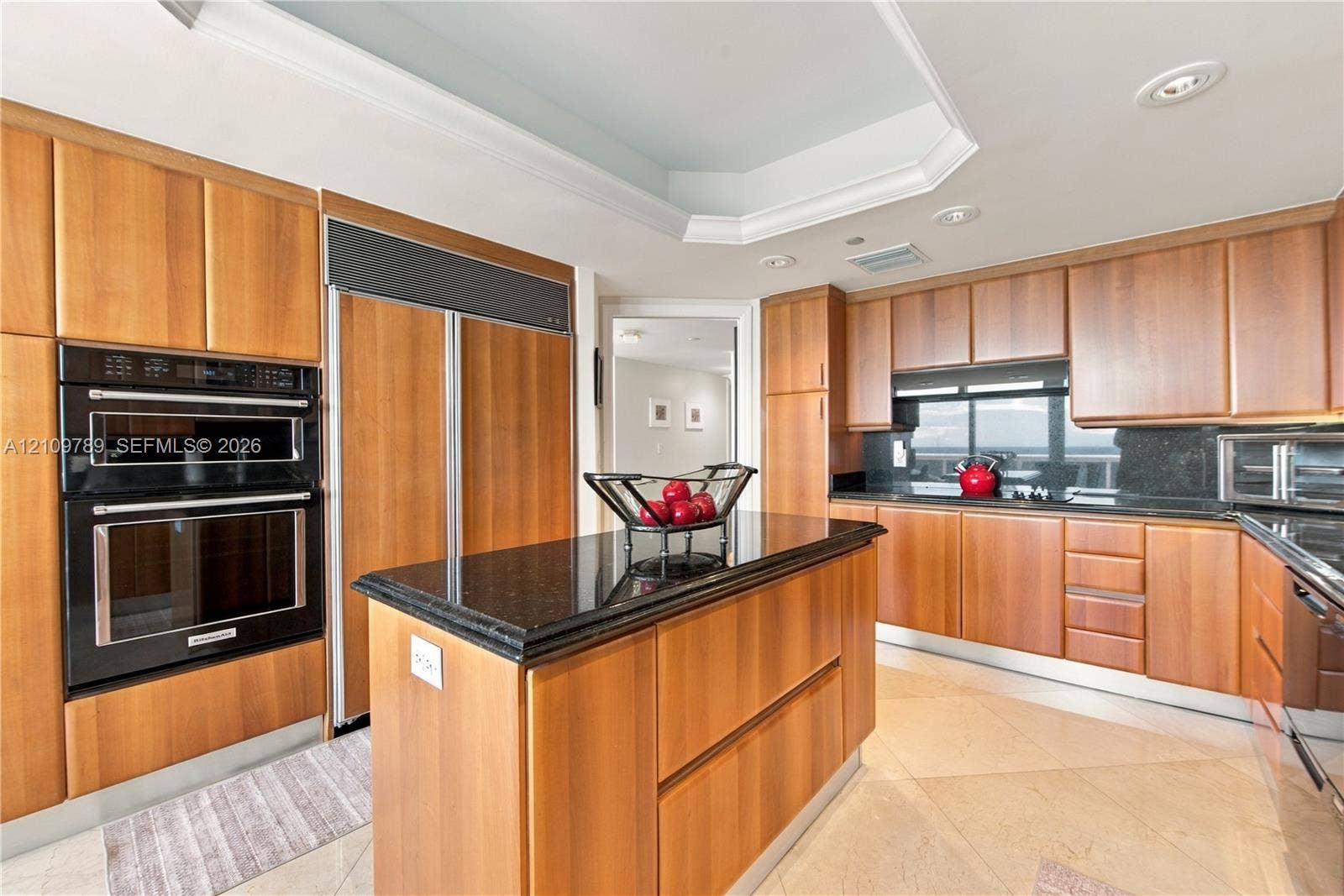 9595 Collins Avenue, #N6-B, Surfside, Surfside, FL 33154 Kitchen featuring wood cabinetry, stone countertops, central island, built-in double oven, and recessed tray ceiling