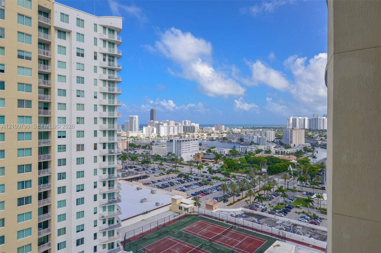 High-rise urban outlook featuring dual tennis courts, expansive skyline exposure, and coastal proximity