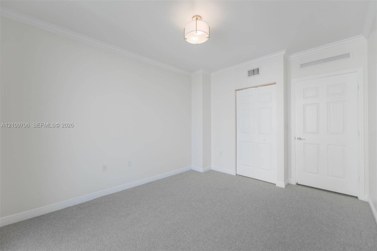 Neutral wall coloring, crown molding, wall-to-wall carpeting, dual-panel interior doors, and a semi-flush mount ceiling fixture
