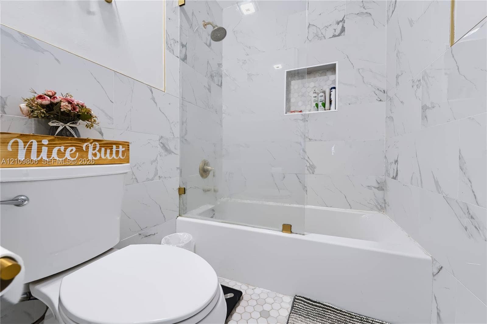 9123 SW 117th Court, Miami, FL 33186 Full-height stone-look tile wall surround, glass partition, integrated built-in shower niche, and white porcelain fixtures
