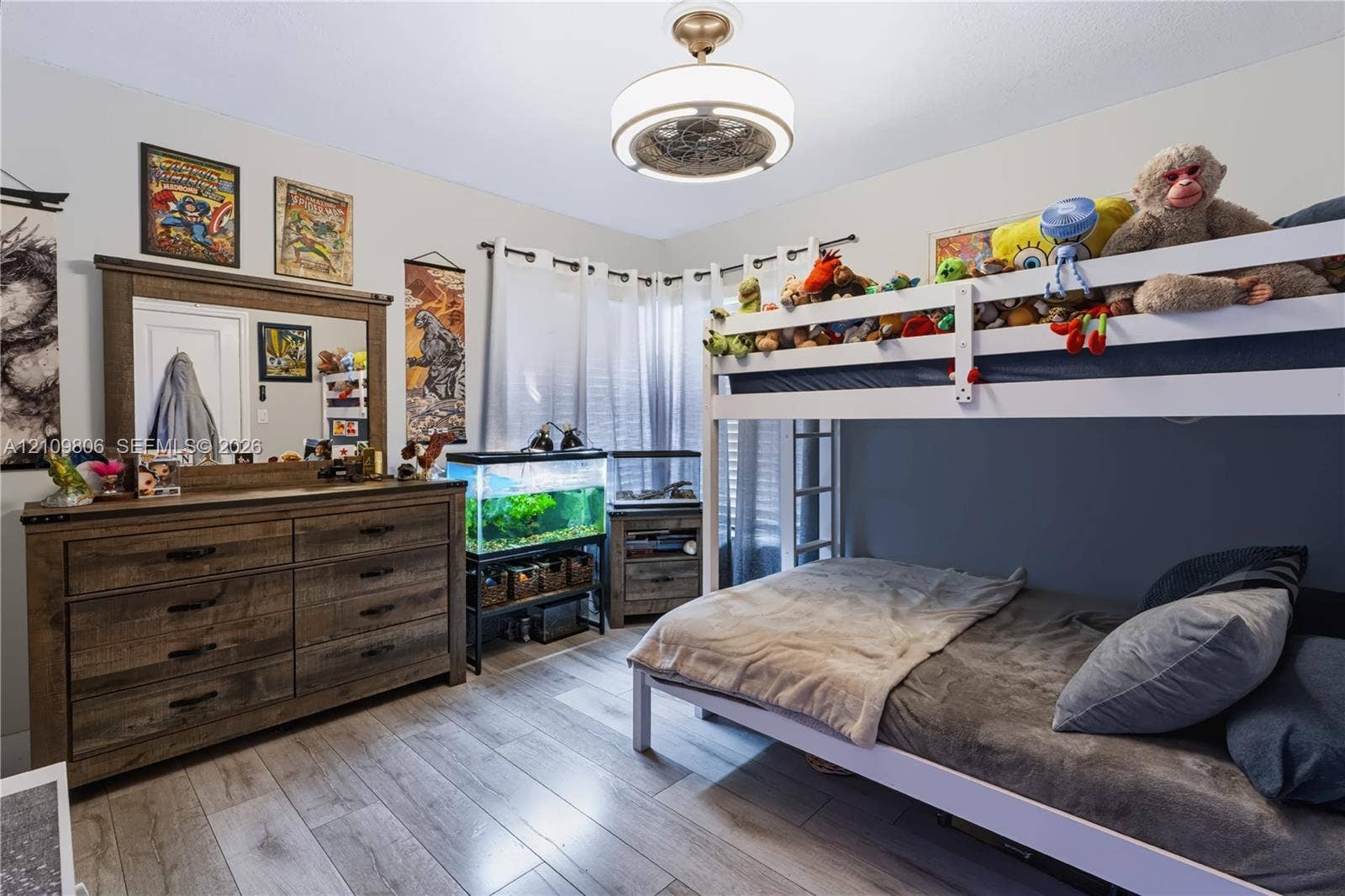 9123 SW 117th Court, Miami, FL 33186 Wood-finish flooring, neutral wall color, and a modern drum-style ceiling light fixture with a decorative central fan