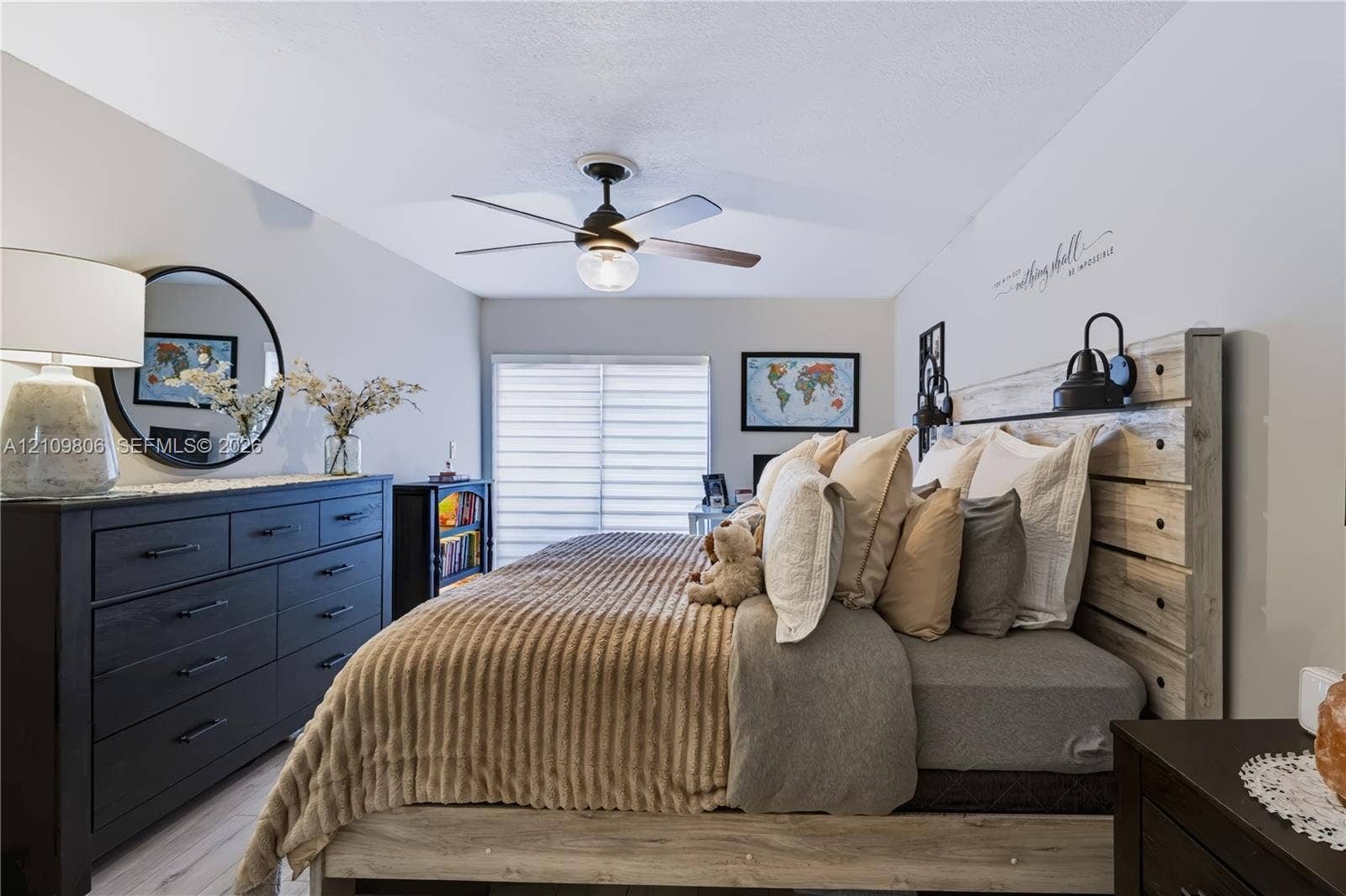 9123 SW 117th Court, Miami, FL 33186 Neutral-toned interior featuring wood-finish flooring, a contemporary ceiling fan with integrated lighting, and sliding glass doors with horizontal blinds