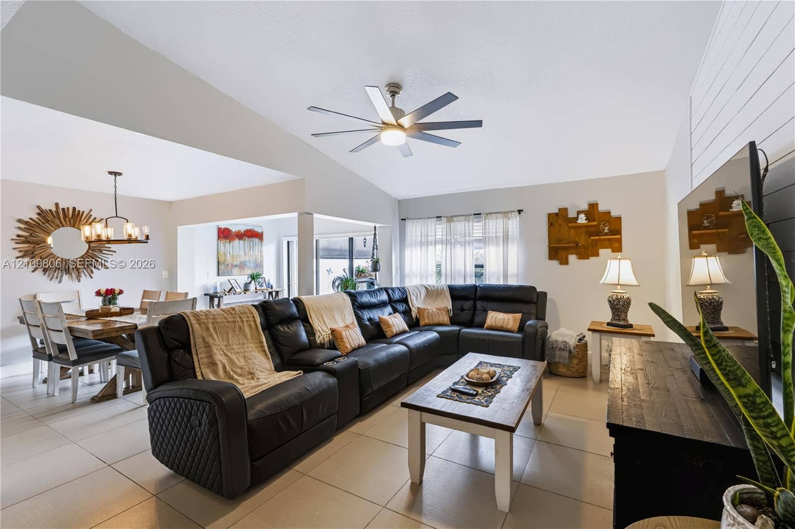 9123 SW 117th Court, Miami, FL 33186 Vaulted ceilings featuring a multi-blade ceiling fan, neutral tile flooring, and white shiplap accent wall
