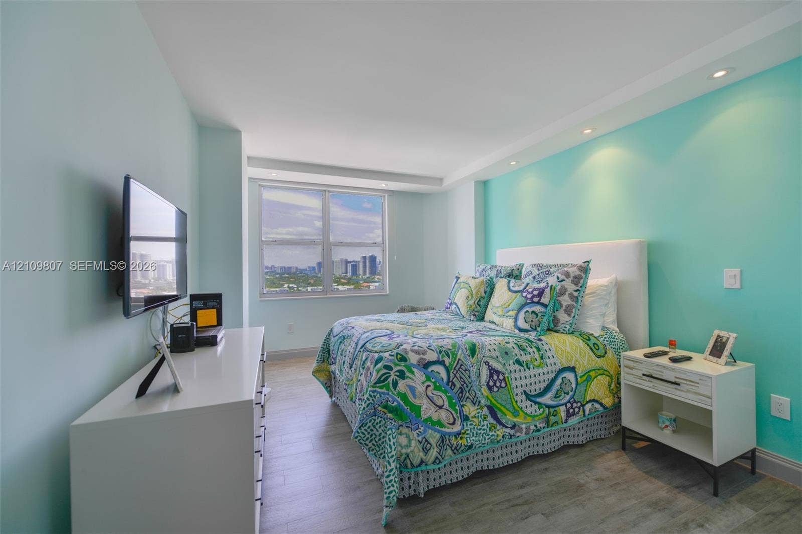1980 S Ocean Drive, #16Q, Hallandale Beach, FL 33009 Bedroom featuring wood-finish flooring, recessed ceiling lighting, and a large window with urban scenery