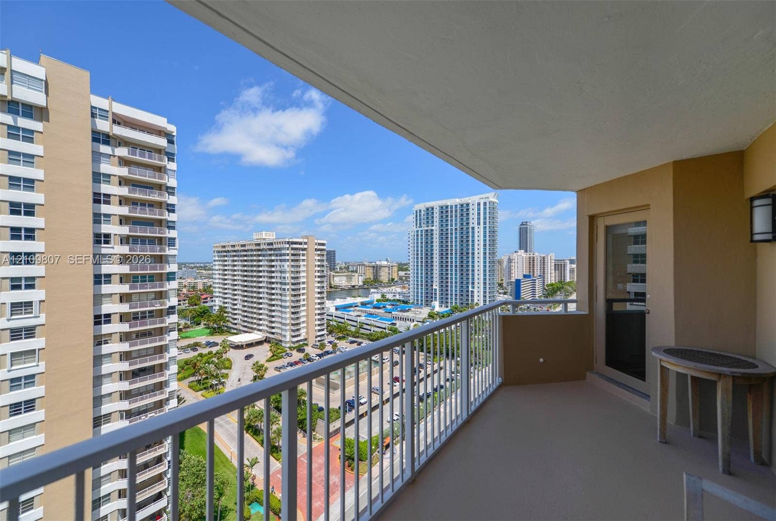 1980 S Ocean Drive, #16Q, Hallandale Beach, FL 33009 Covered private balcony featuring a concrete floor, metal railing, and wall-mounted exterior lighting