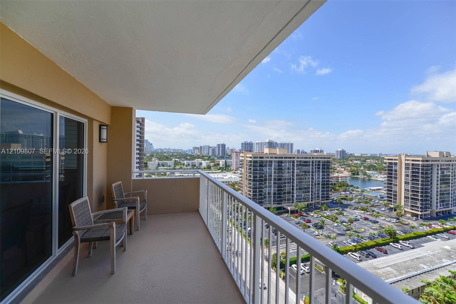 1980 S Ocean Drive, #16Q, Hallandale Beach, FL 33009 Covered balcony featuring concrete flooring, a white metal railing, and wall-mounted exterior lighting