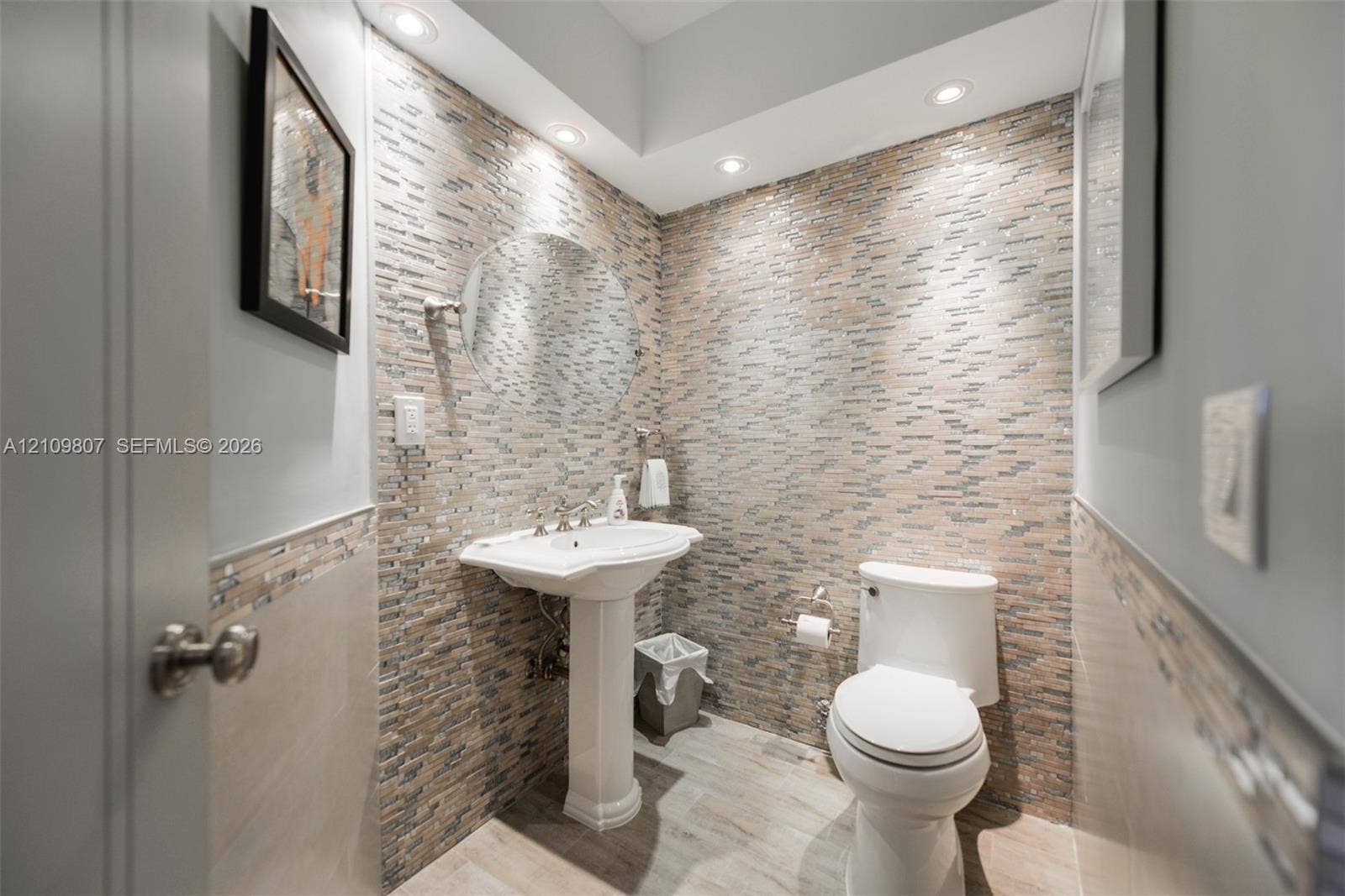1980 S Ocean Drive, #16Q, Hallandale Beach, FL 33009 Powder room featuring a stacked-stone accent wall, pedestal sink, recessed lighting, and wood-finish tile flooring