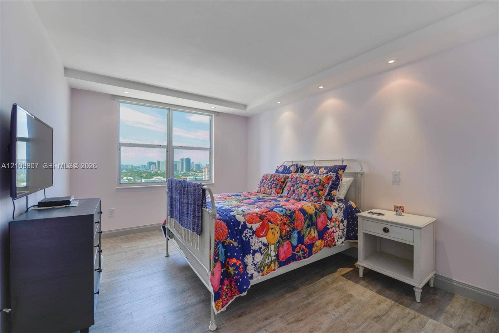 1980 S Ocean Drive, #16Q, Hallandale Beach, FL 33009 Room featuring wood-finish flooring, recessed ceiling lighting, and a large window with urban scenery