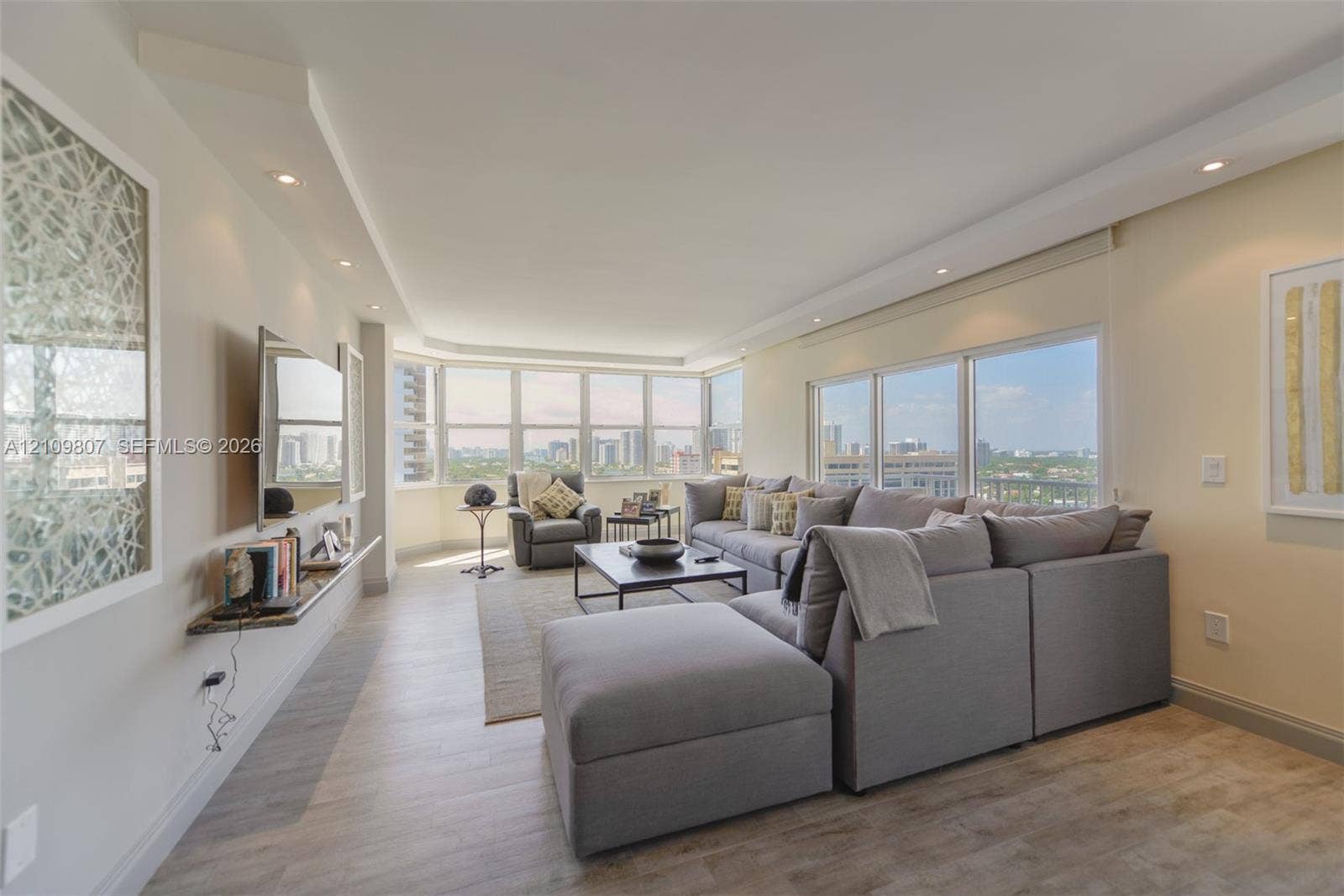 1980 S Ocean Drive, #16Q, Hallandale Beach, FL 33009 Living area featuring wood-finish flooring, extensive floor-to-ceiling windows, recessed ceiling lighting, and a wall-mounted stone shelf