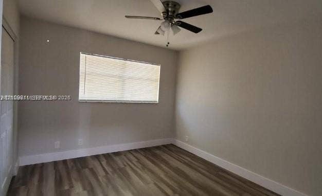 450 SW 2nd Street, #8, Pompano Beach, Pompano Beach, FL 33060 Neutral-toned interior space featuring wood-finish flooring, a ceiling fan with integrated lighting, and a single-panel interior door