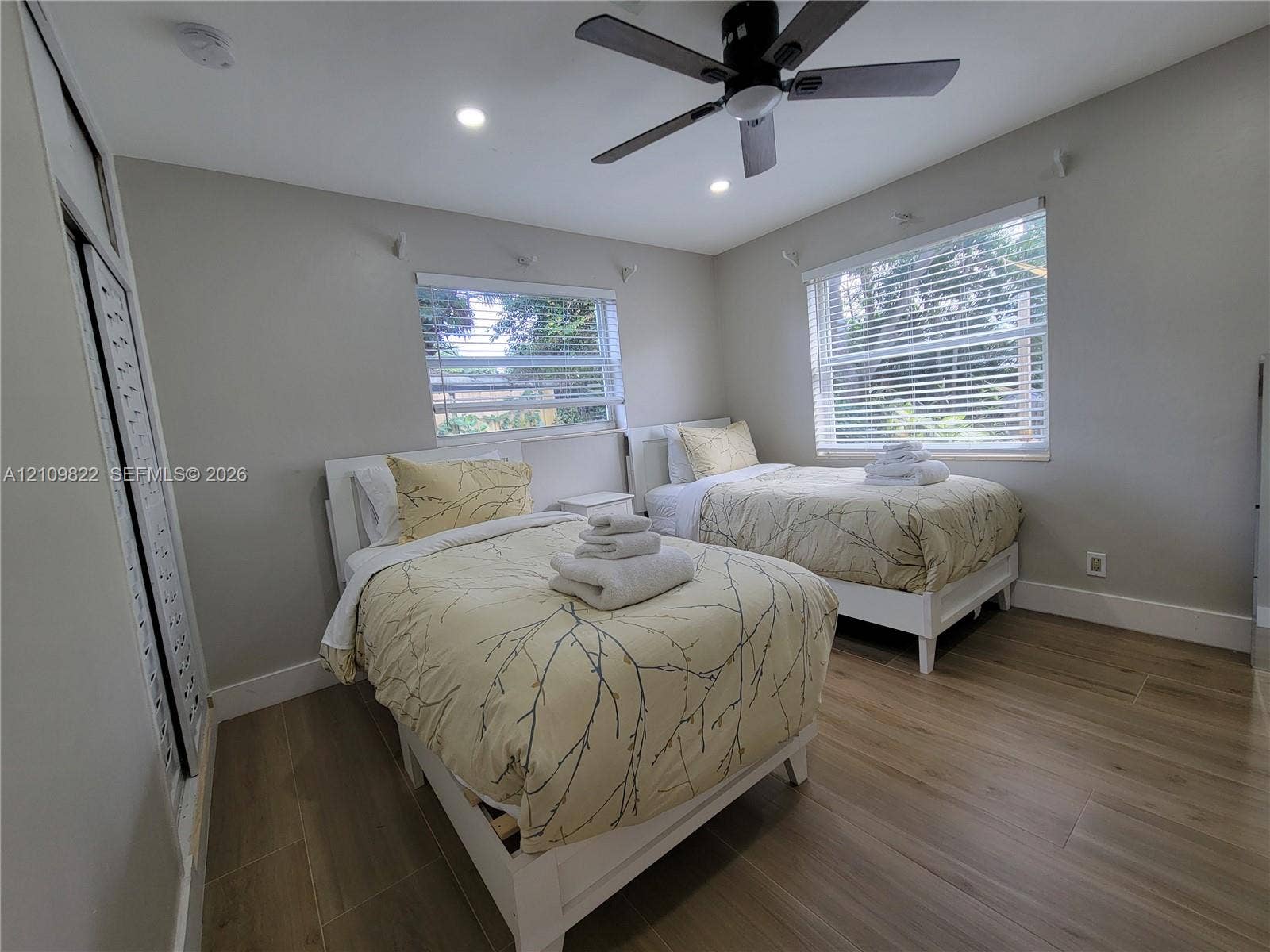 913 Lighthouse Drive, North Palm Beach, North Palm Beach, FL 33408 Bedroom featuring wood-finish flooring, recessed lighting, a ceiling fan, dual windows, and closet storage with louvered doors