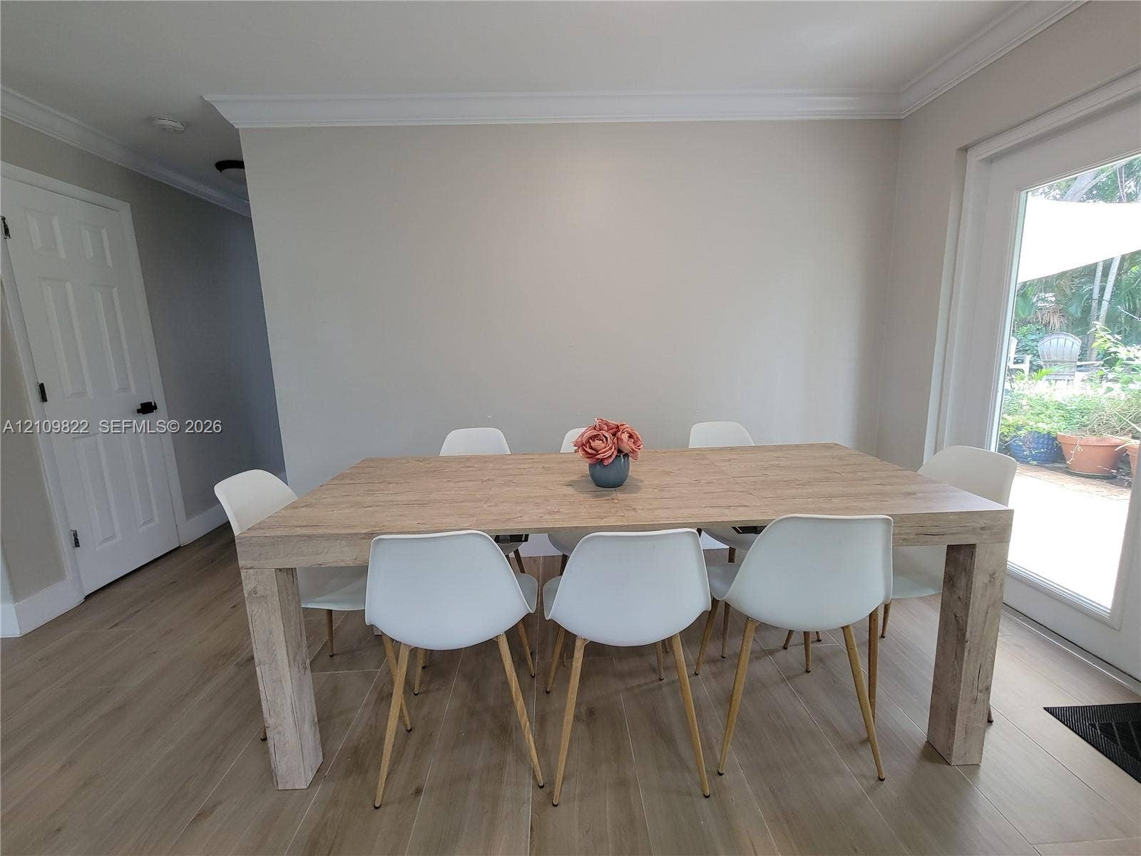 913 Lighthouse Drive, North Palm Beach, North Palm Beach, FL 33408 Neutral wall color with crown molding, wood-finish flooring, and a glass-paneled exterior door