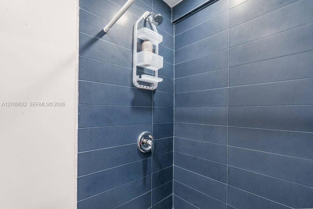 913 Lighthouse Drive, North Palm Beach, North Palm Beach, FL 33408 Shower surround featuring large-format dark blue rectangular wall tiles and a polished chrome single-handle mixing valve