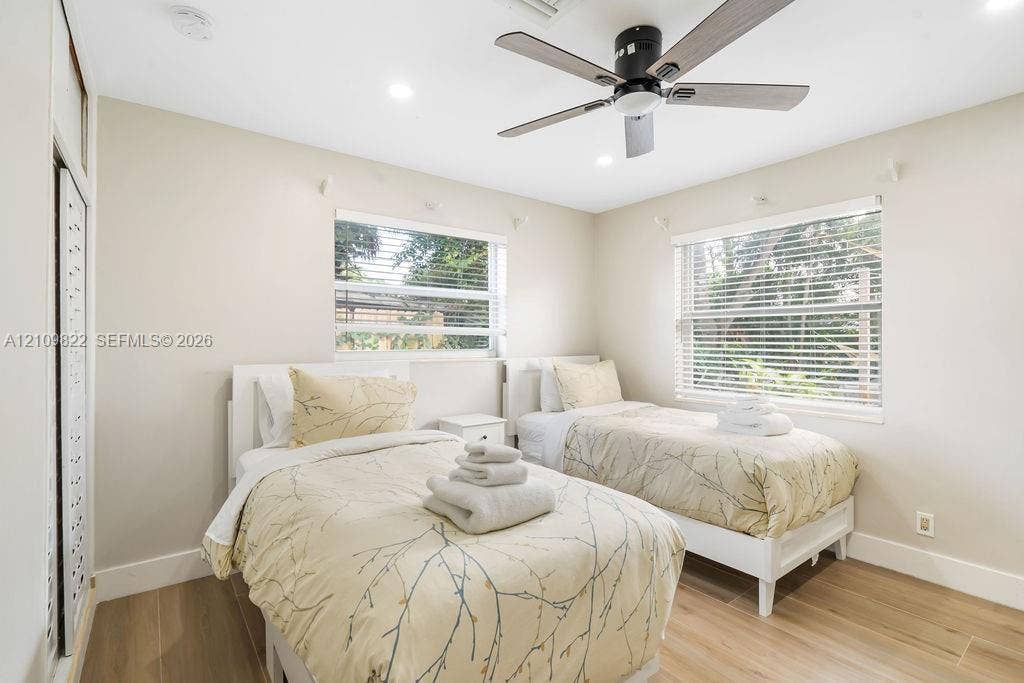 913 Lighthouse Drive, North Palm Beach, North Palm Beach, FL 33408 Neutral-toned interior featuring wood-finish tile flooring, recessed ceiling lighting, a matte black multi-blade ceiling fan, and horizontal window blinds