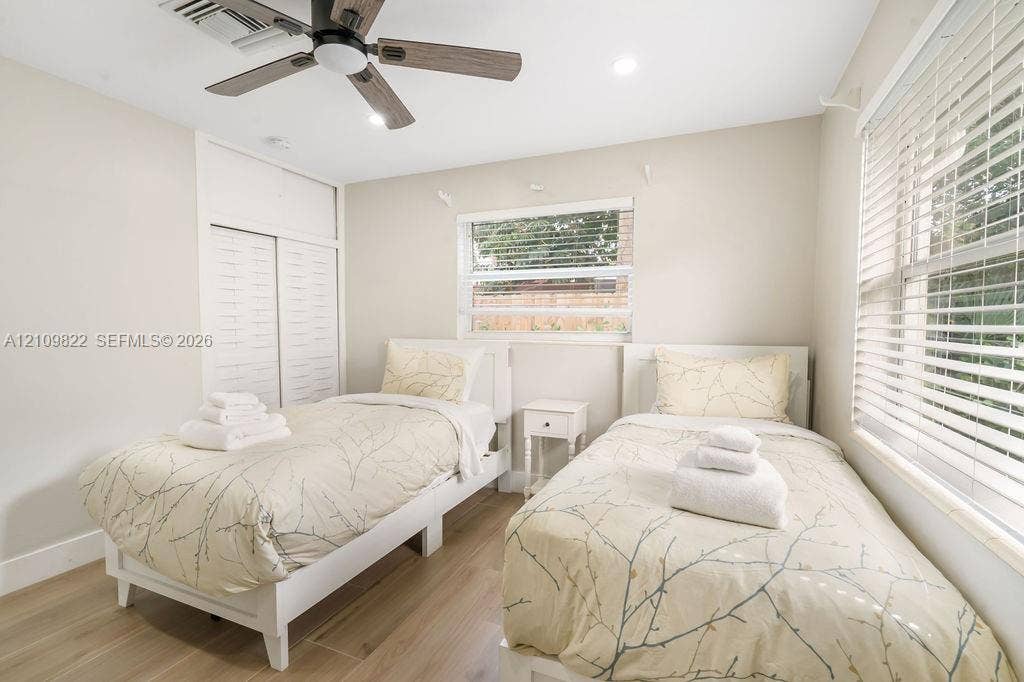 913 Lighthouse Drive, North Palm Beach, North Palm Beach, FL 33408 Neutral-toned interior featuring wood-finish flooring, a multi-blade ceiling fan, recessed lighting, and dual-window installations with horizontal blinds