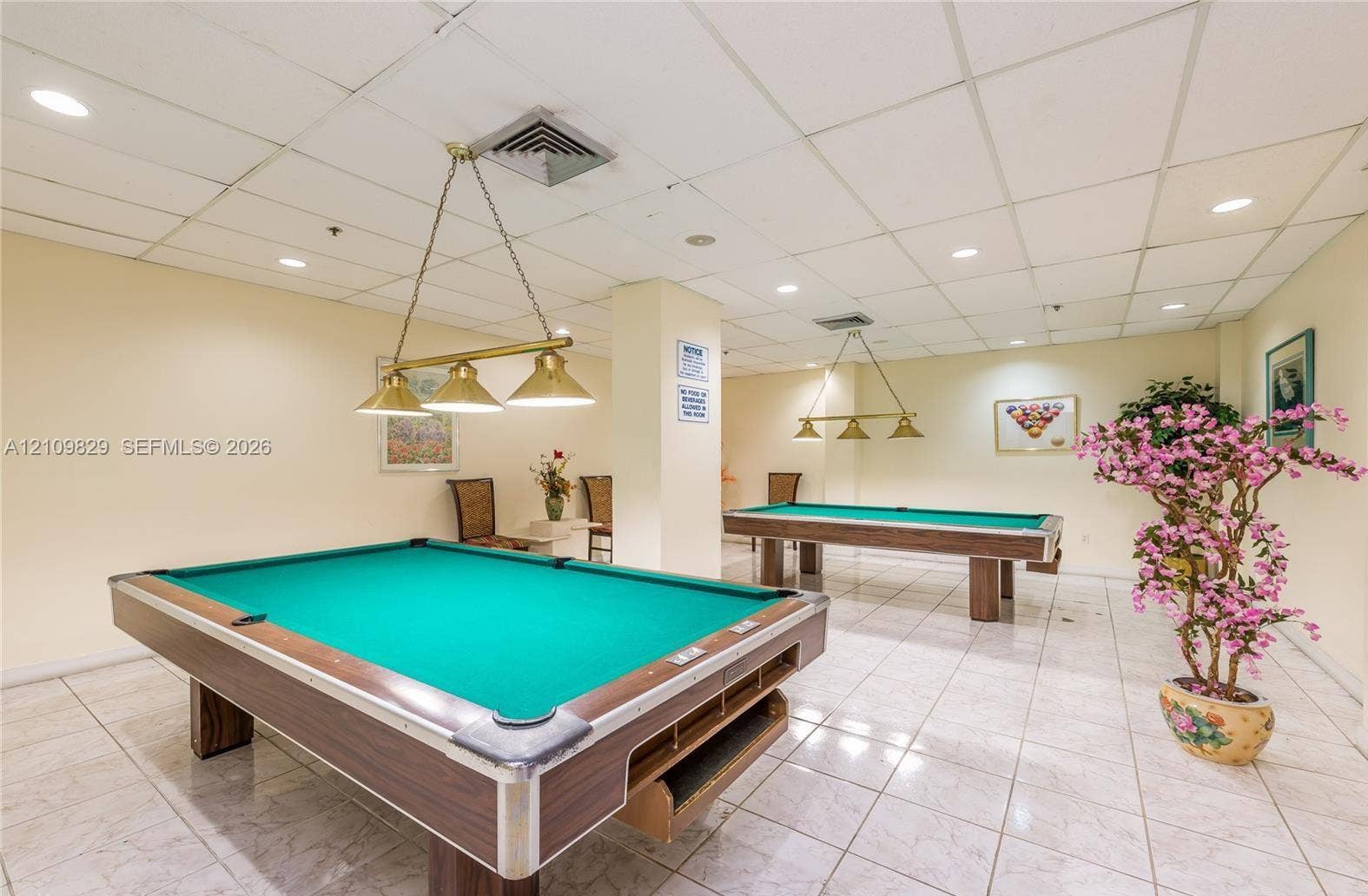 Spacious interior featuring recessed ceiling lighting, light-toned ceramic tile flooring, and multi-light hanging fixtures