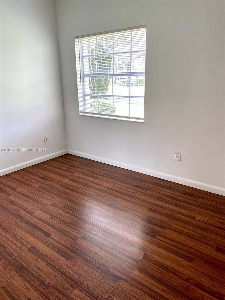 Wood-finish flooring and a single-pane window with integrated horizontal blinds