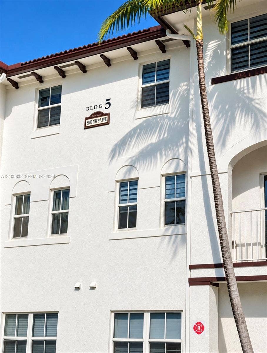 8800 NW 97th Avenue, #205, Doral, FL 33178 Stucco exterior featuring decorative corbels, arched window detailing, and a private balcony with metal railings