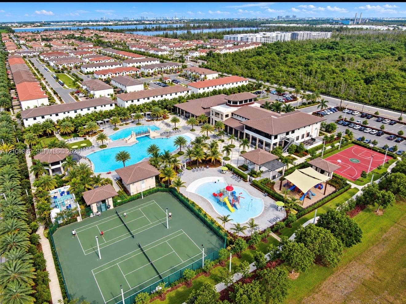 8800 NW 97th Avenue, #205, Doral, FL 33178 Aerial perspective of a community recreation complex featuring swimming pools with bridge and splash features, tennis courts, basketball court, and clubhouse facility