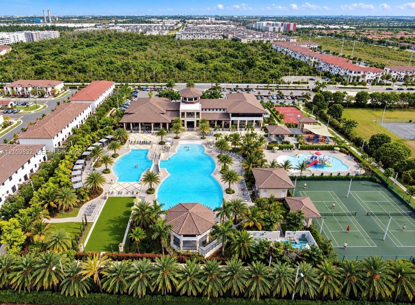 8800 NW 97th Avenue, #205, Doral, FL 33178 Community recreation complex featuring a large resort-style swimming pool, multiple tennis courts, a splash pad, and a clubhouse with a central tower