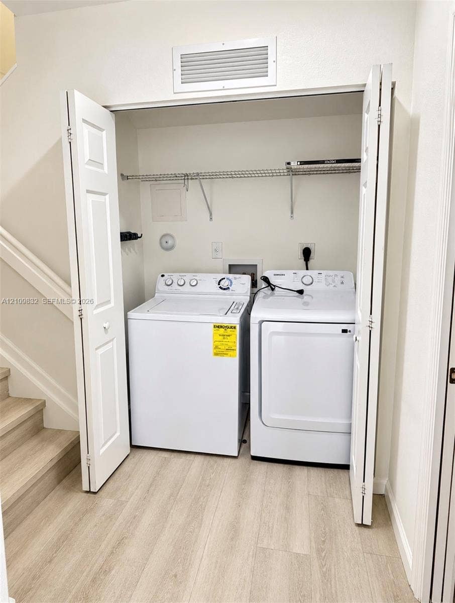 8800 NW 97th Avenue, #205, Doral, FL 33178 Laundry closet featuring bifold doors, wood-finish flooring, and wire shelving