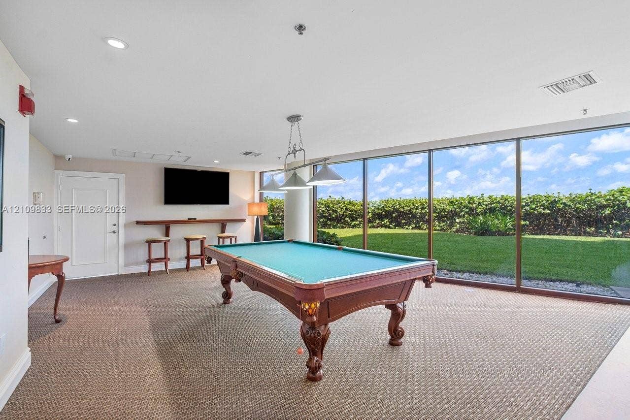 530 Ocean Drive, #405, Juno Beach, FL 33408 Interior room featuring floor-to-ceiling windows, wall-to-wall carpeting, recessed lighting, and a built-in wooden bar shelf