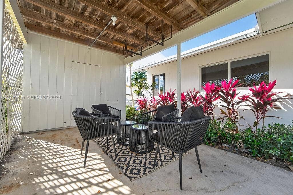 756 Cinnamon Road, North Palm Beach, North Palm Beach, FL 33408 Covered patio featuring a concrete floor, wooden slat ceiling, lattice screen, and exterior wall cladding