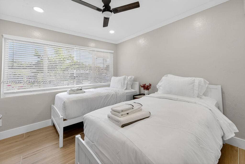 756 Cinnamon Road, North Palm Beach, North Palm Beach, FL 33408 Room featuring wood-finish flooring, recessed lighting, crown molding, a multi-blade ceiling fan, and a large window with horizontal blinds