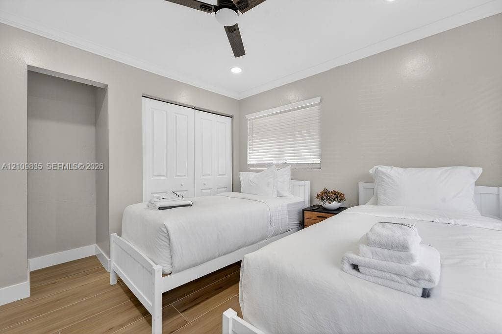 756 Cinnamon Road, North Palm Beach, North Palm Beach, FL 33408 Room featuring wood-finish tile flooring, dual-panel closet doors, recessed lighting, ceiling fan with integrated lighting, and horizontal window blinds