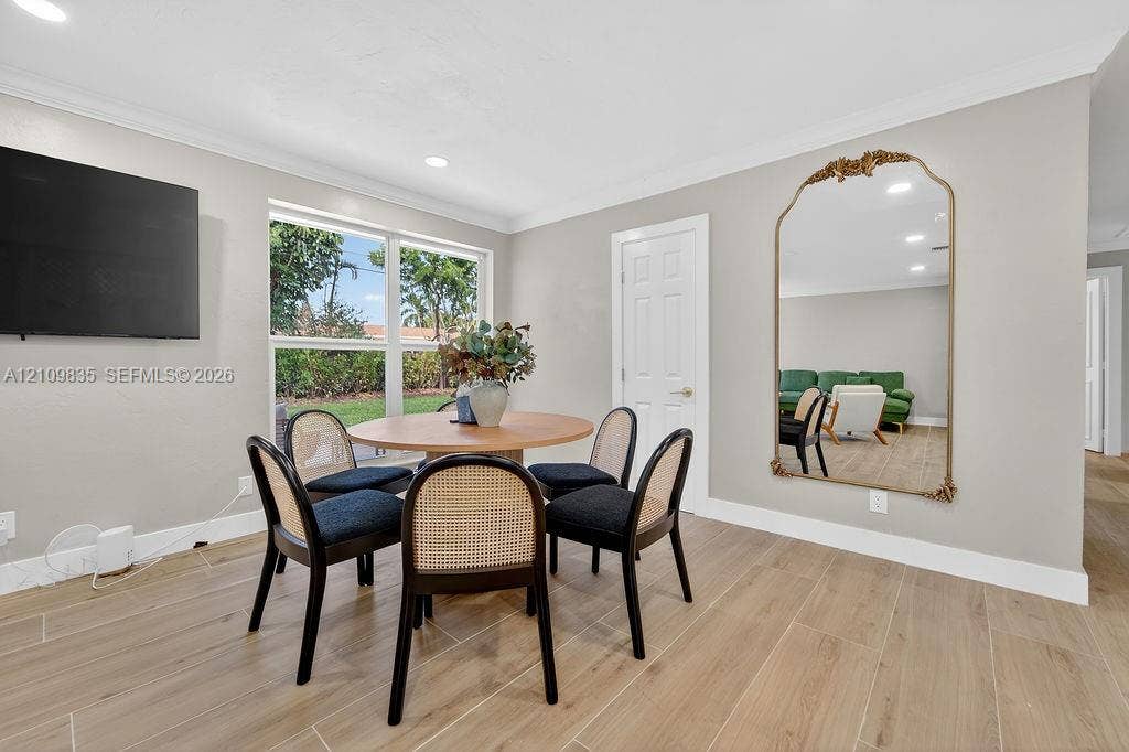 756 Cinnamon Road, North Palm Beach, North Palm Beach, FL 33408 Neutral interior space featuring wood-finish tile flooring, recessed lighting, crown molding, and a large multi-pane window