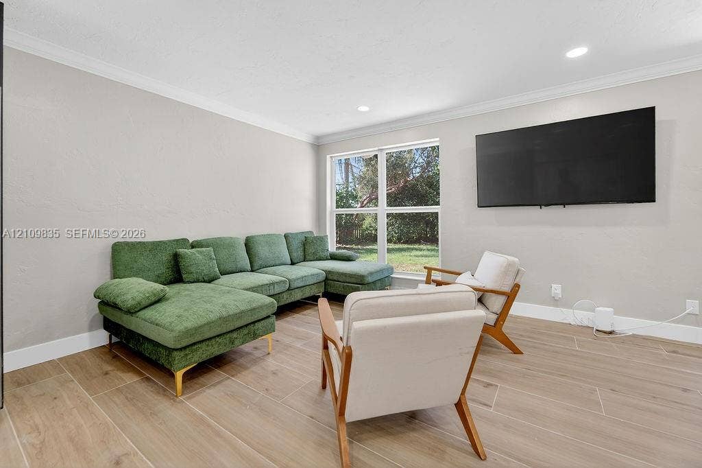 756 Cinnamon Road, North Palm Beach, North Palm Beach, FL 33408 Neutral-toned interior featuring wood-finish tile flooring, crown molding, recessed lighting, and large windows