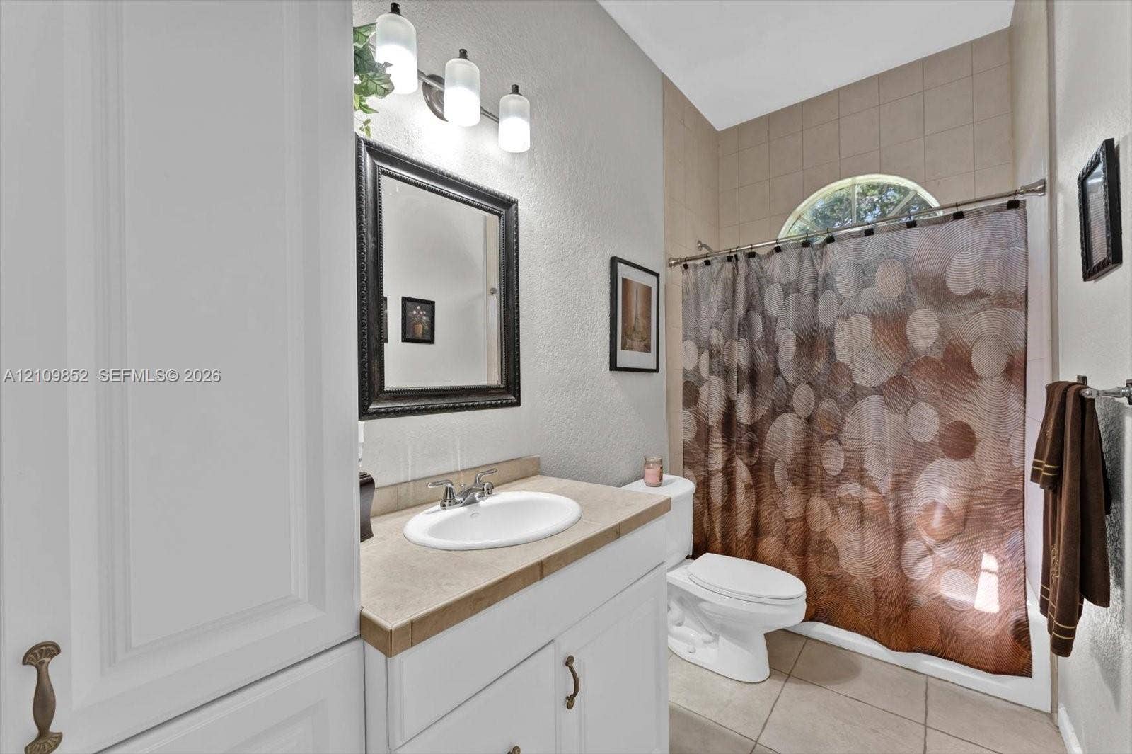 7901 SW 97th Street, Miami, FL 33156 Hall bathroom featuring a shower-tub combination with a semi-circular transom window *