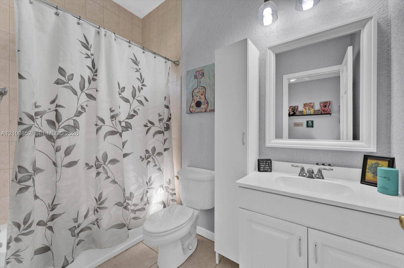 7901 SW 97th Street, Miami, FL 33156 Ensuite bathroom featuring a vanity with an integrated countertop sink, tall storage cabinetry, framed wall mirror, and a combination tub/shower *