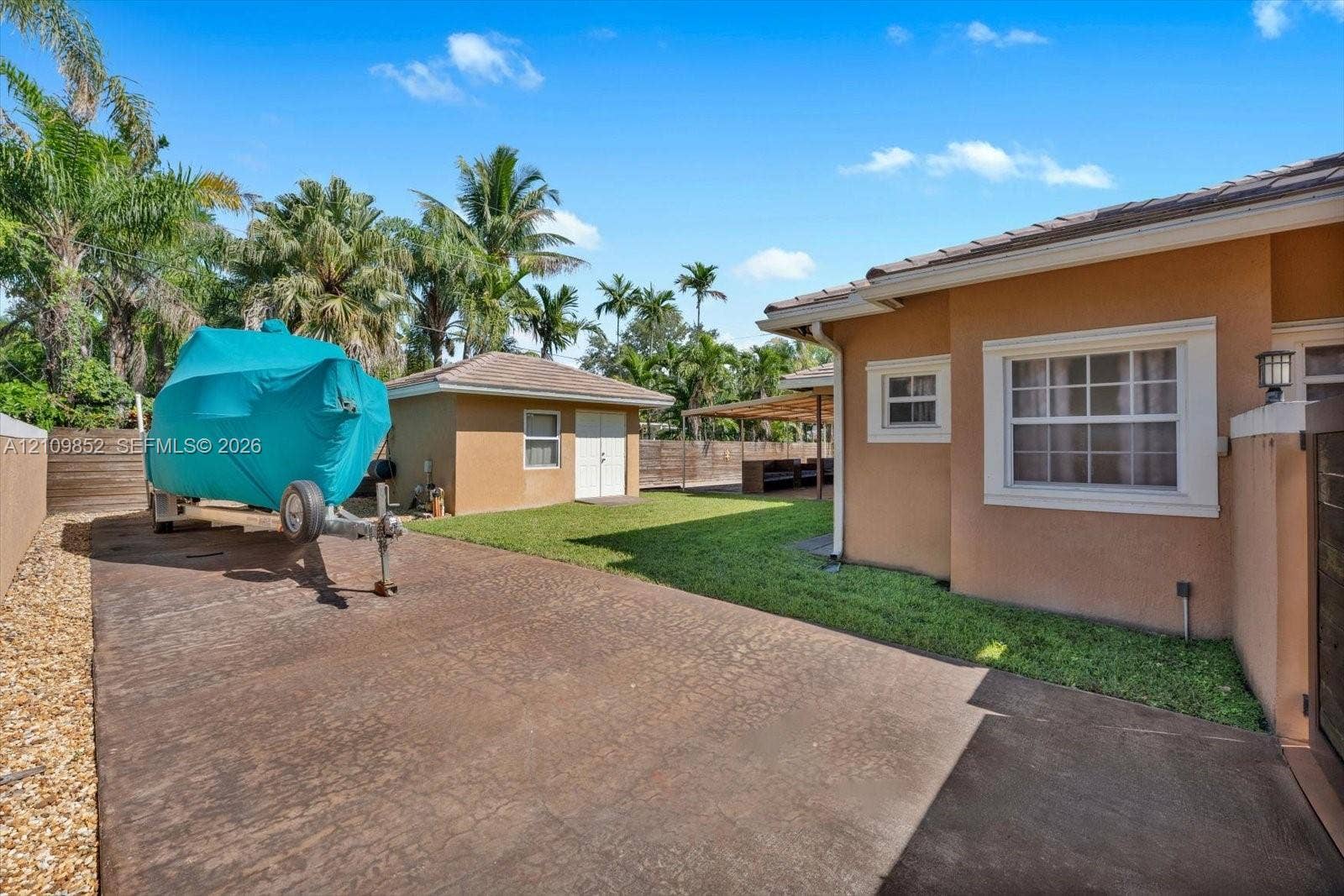 7901 SW 97th Street, Miami, FL 33156 Extended concrete driveway in the back yard perfect for RV, Boat or extra car storage * View of the detached CBS shed in the background * Concrete wall on the side *
