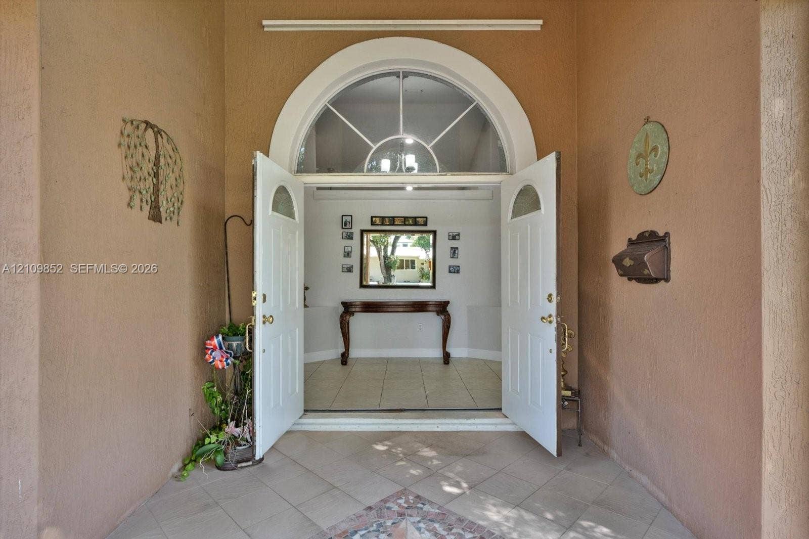 7901 SW 97th Street, Miami, FL 33156 Covered entryway featuring a tiled porch and double doors with an arched fanlight window
