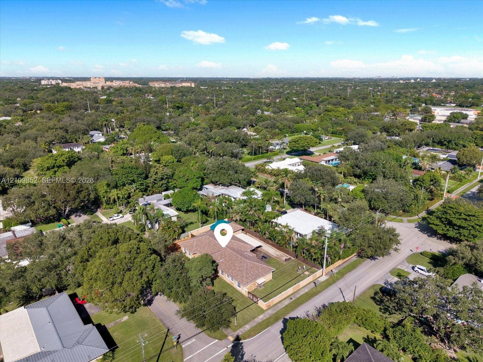 7901 SW 97th Street, Miami, FL 33156 Aerial perspective of this single-story residence on a corner lot featuring a multi-hipped roof, perimeter fencing, and mature landscaping