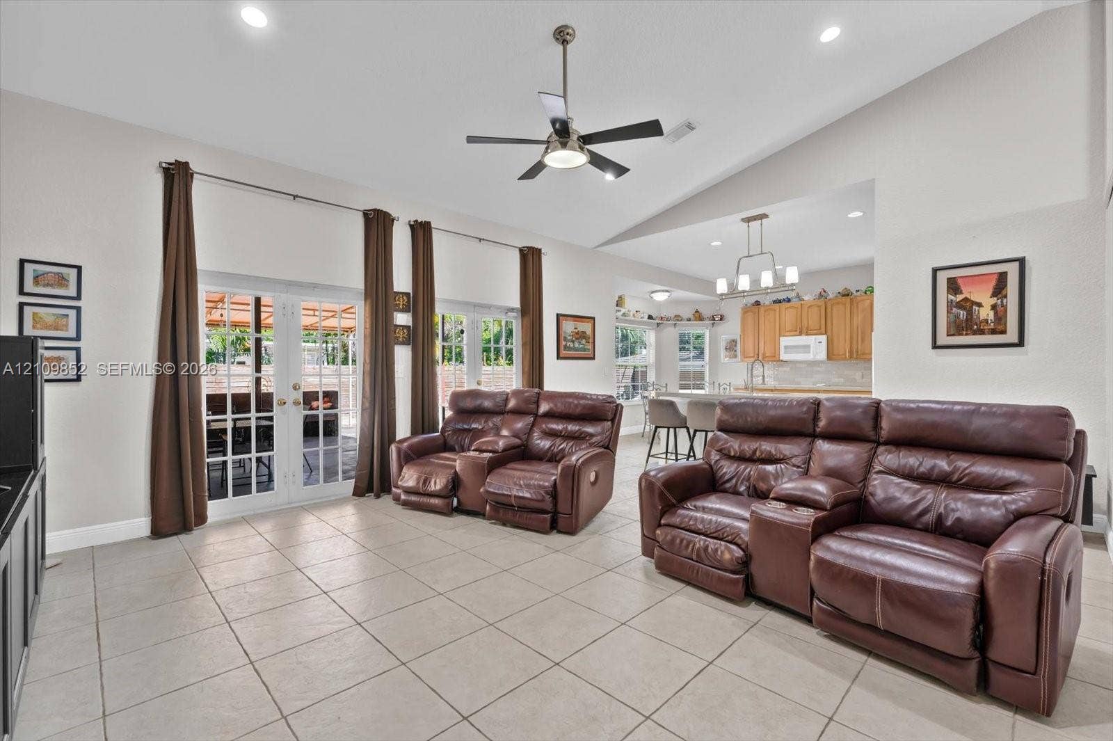 7901 SW 97th Street, Miami, FL 33156 Open-concept area featuring volume ceilings, neutral ceramic tile flooring, recessed lighting, a modern ceiling fan, and dual glass-panel French doors