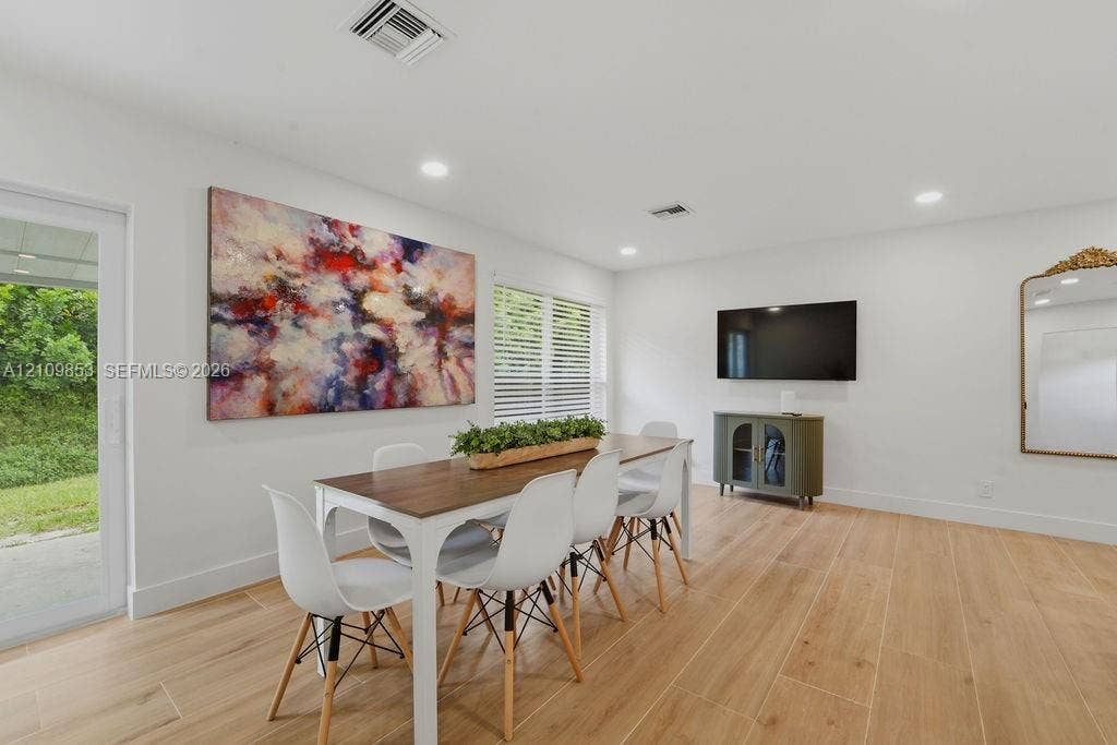 800 Alamanda Drive, North Palm Beach, North Palm Beach, FL 33408 Wood-finish flooring, recessed lighting, and a glass-paneled sliding door providing access to the exterior
