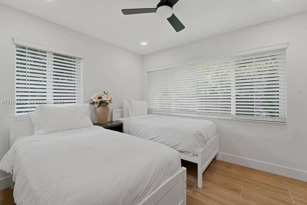 800 Alamanda Drive, North Palm Beach, North Palm Beach, FL 33408 Interior room featuring wood-finish flooring, recessed lighting, a matte black ceiling fan, and large windows with horizontal blinds