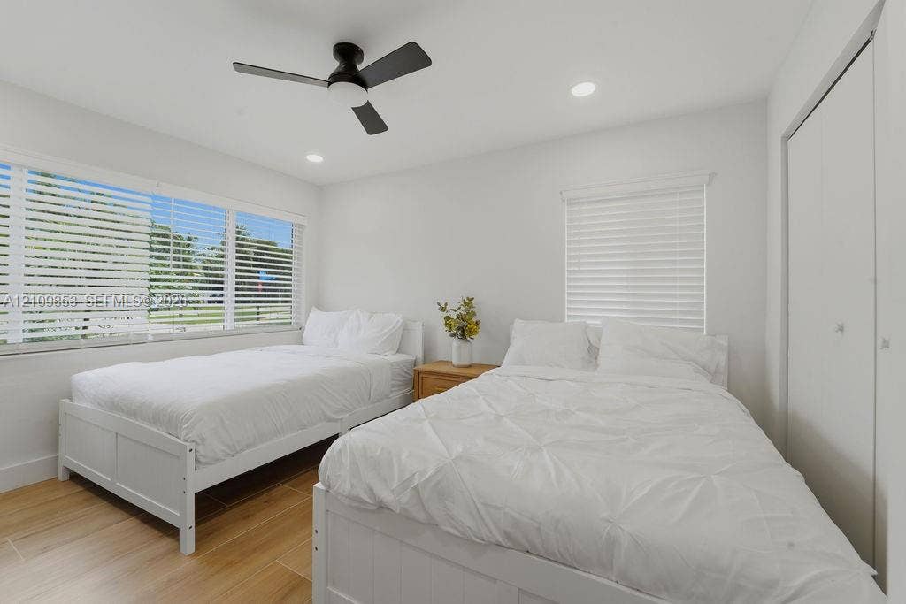 800 Alamanda Drive, North Palm Beach, North Palm Beach, FL 33408 Bedroom featuring wood-finish tile flooring, recessed lighting, matte black ceiling fan, and horizontal window blinds